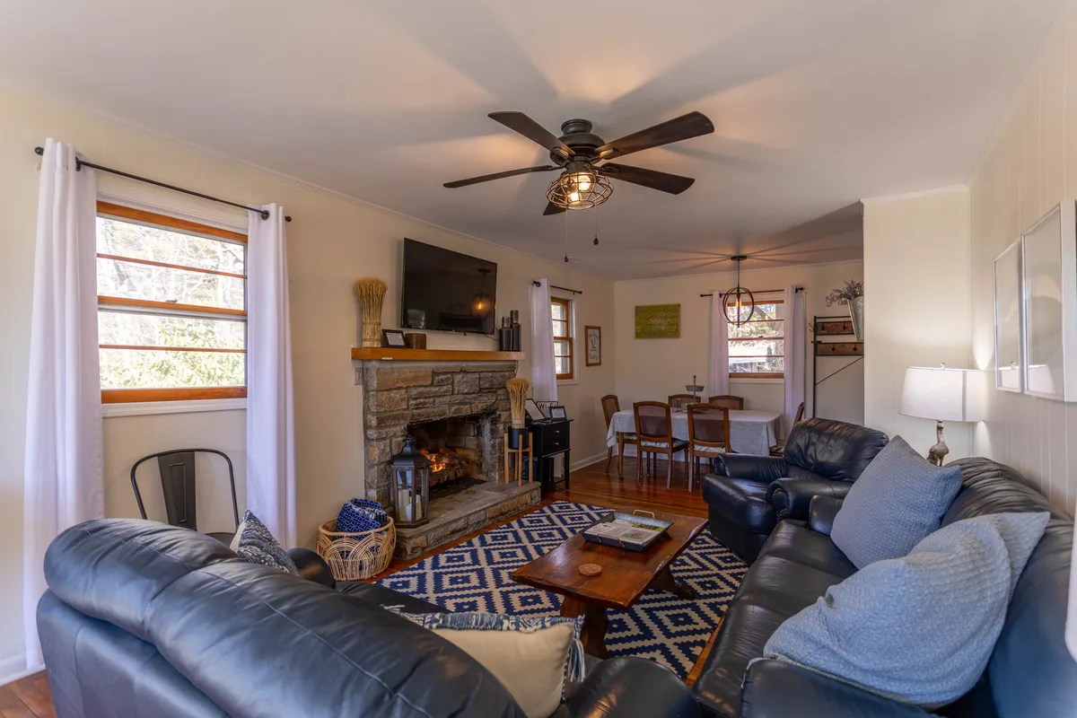 A warmly lit living area featuring a gas fireplace flanked by a comfortable sofa and a dining table, inviting couples to relax or share a meal. Subtle decor, soft lighting, and a cozy rug create an intimate and welcoming atmosphere perfect for romantic evenings.